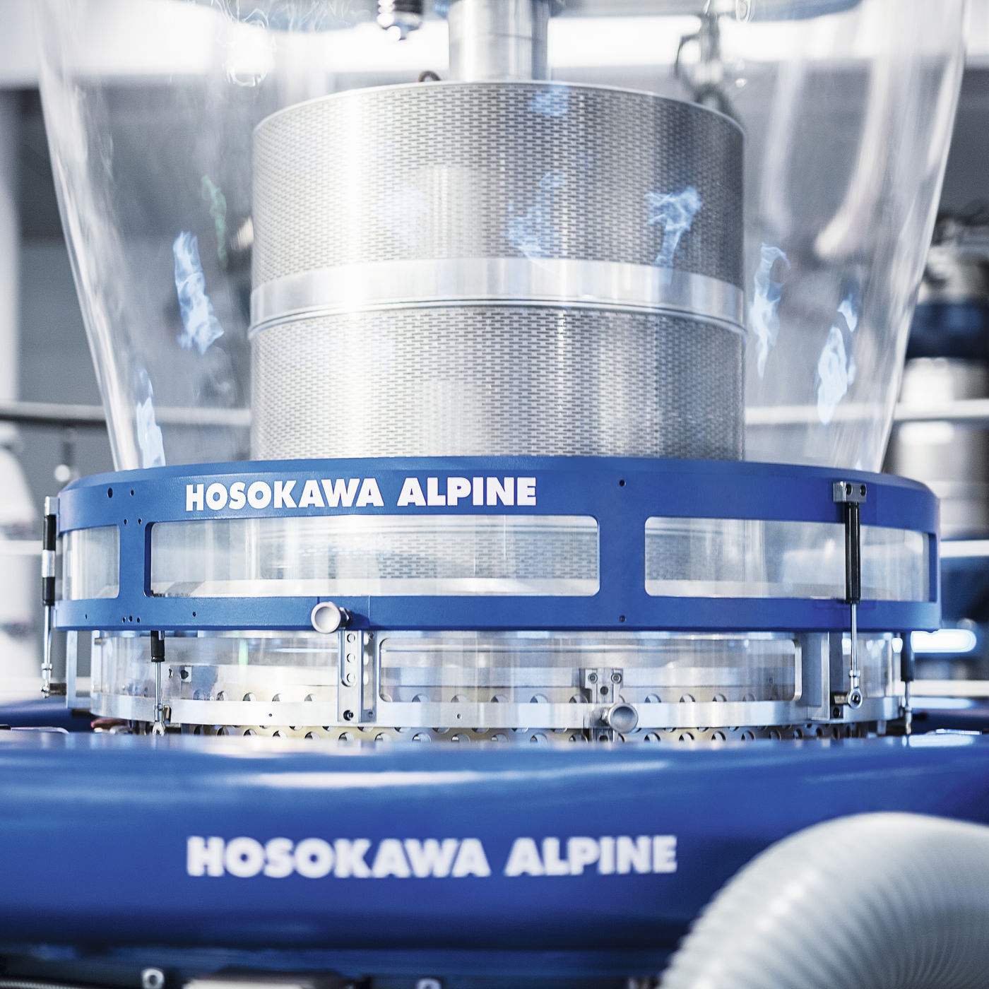 Zbliżenie linii do wytłaczania folii z napisem Hosokawa Alpine.